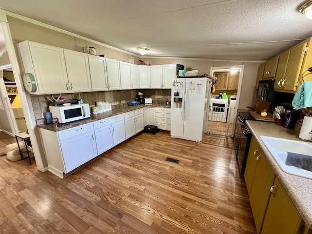 kitchen featuring a sink, backsplash, black appliances, and wood finished floors