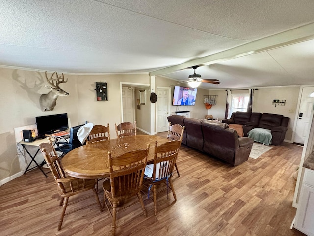 dining space with baseboards, a textured ceiling, ceiling fan, and light wood-style flooring