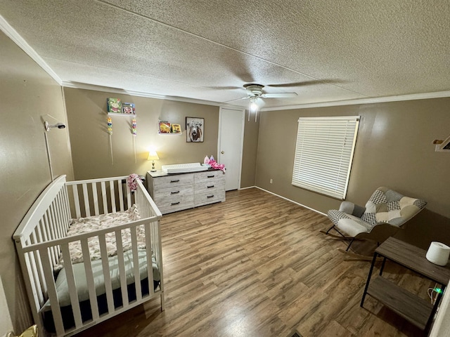 bedroom with crown molding, a ceiling fan, a textured ceiling, and wood finished floors