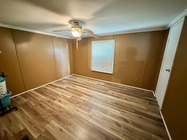 unfurnished bedroom with ornamental molding, a ceiling fan, and wood finished floors
