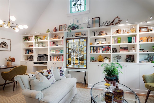 sitting room with high vaulted ceiling, light wood-type flooring, and a chandelier