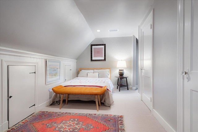 bedroom with baseboards, vaulted ceiling, light colored carpet, and visible vents