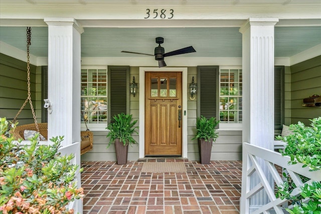 entrance to property featuring covered porch and a ceiling fan