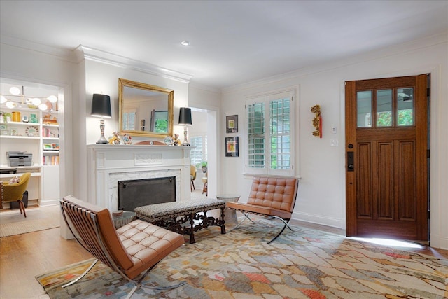 living room featuring crown molding, baseboards, wood finished floors, and a fireplace