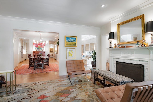living area featuring crown molding, a premium fireplace, wood finished floors, and a notable chandelier