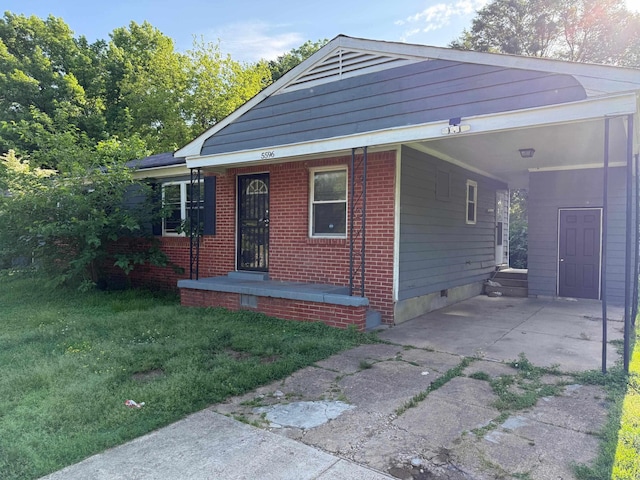 view of front facade with crawl space, driveway, a carport, brick siding, and a front lawn