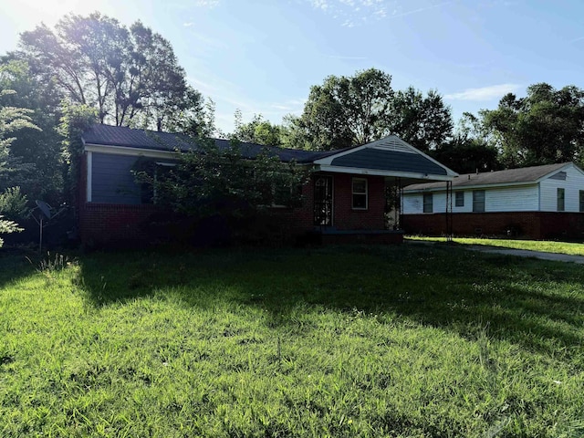 ranch-style house with brick siding, a carport, and a front lawn