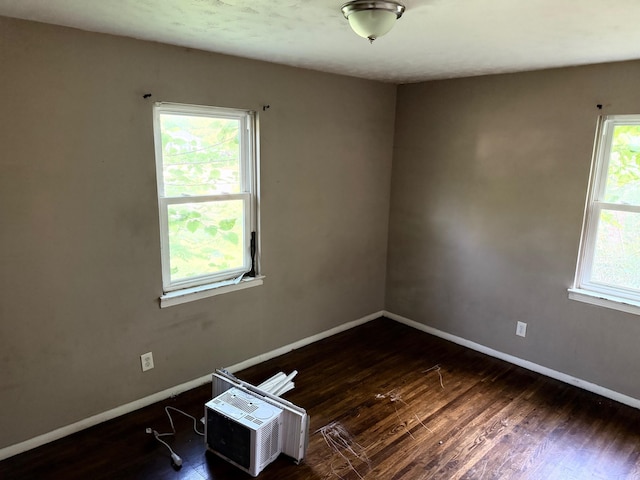 spare room featuring baseboards and wood finished floors