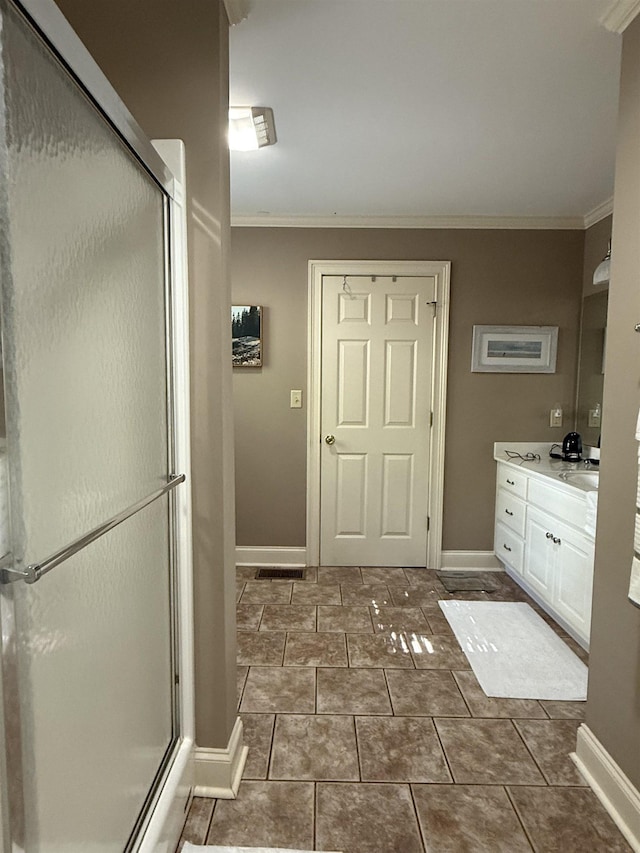 bathroom with baseboards, ornamental molding, and a shower stall