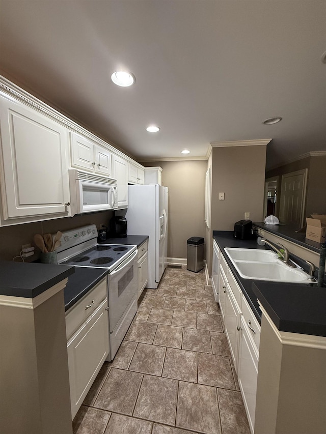 kitchen featuring crown molding, dark countertops, white appliances, white cabinets, and a sink