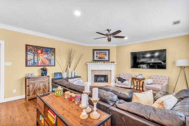 living room with crown molding, ceiling fan, visible vents, and baseboards