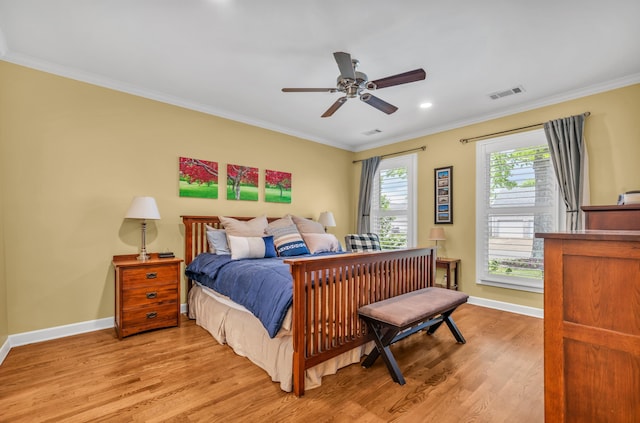 bedroom featuring baseboards, visible vents, ornamental molding, and light wood-style flooring
