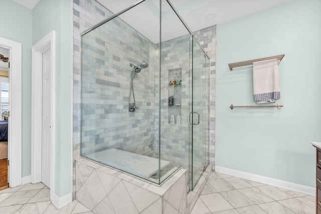 bathroom with vanity, baseboards, a stall shower, and ensuite bath
