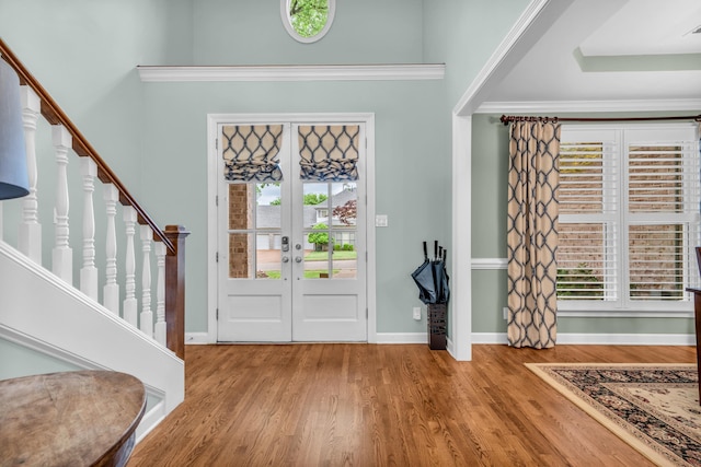 entryway featuring baseboards, french doors, stairs, and wood finished floors
