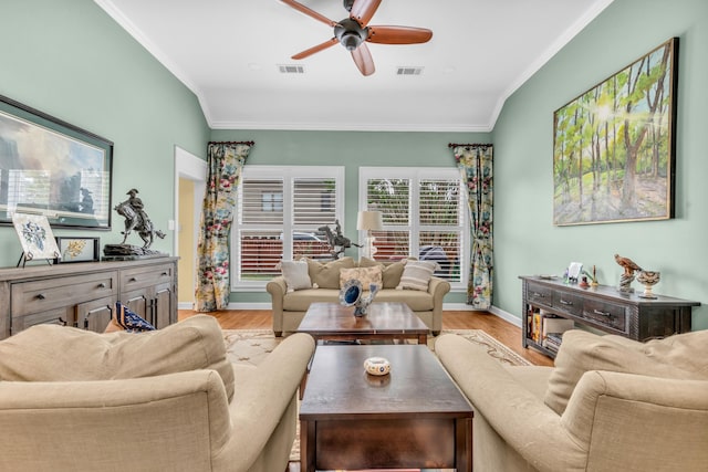 living area with crown molding, light wood-style floors, a ceiling fan, baseboards, and visible vents