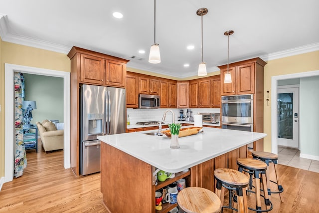 kitchen with appliances with stainless steel finishes, ornamental molding, and brown cabinetry