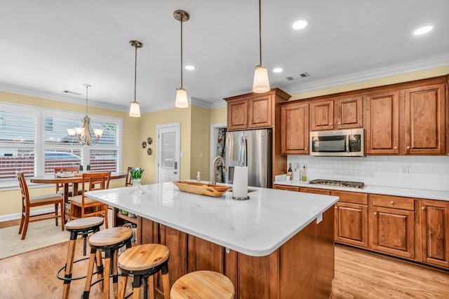 kitchen featuring visible vents, crown molding, light wood-type flooring, brown cabinets, and appliances with stainless steel finishes