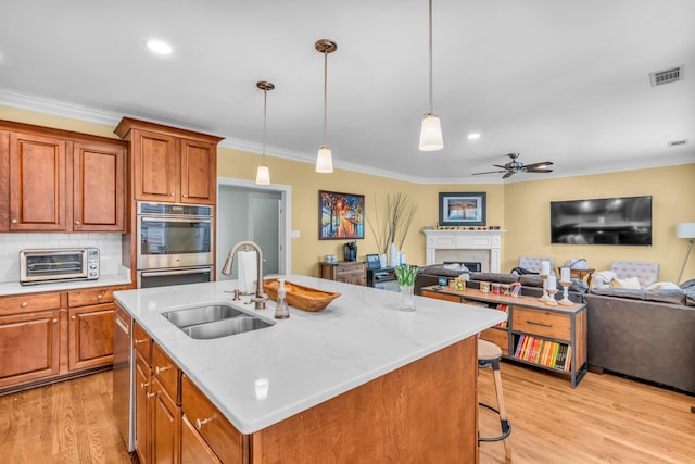 kitchen with crown molding, appliances with stainless steel finishes, a sink, a toaster, and visible vents