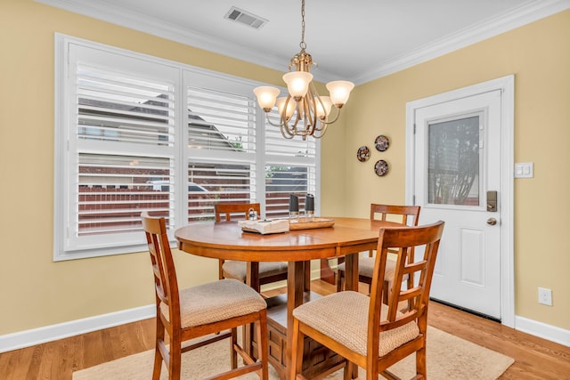 dining room featuring crown molding, baseboards, light wood-style floors, and visible vents