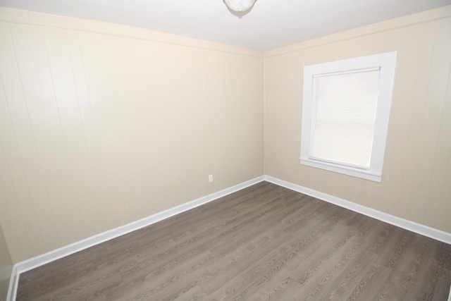 empty room featuring baseboards and dark wood-style floors