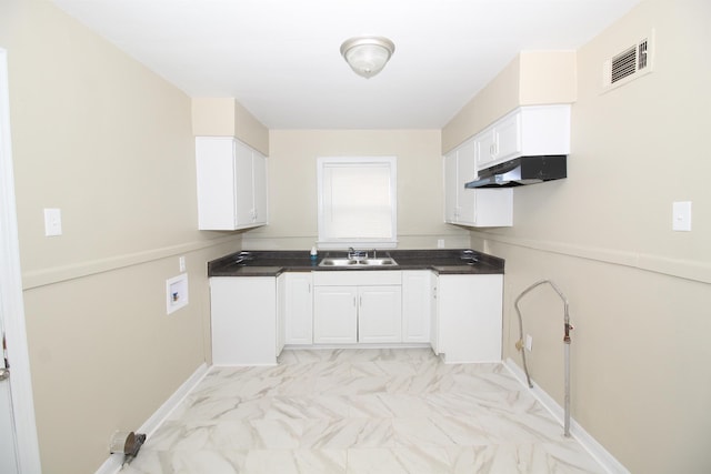 kitchen with visible vents, marble finish floor, under cabinet range hood, white cabinets, and a sink