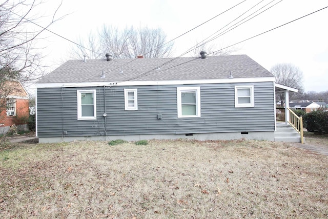 rear view of house featuring roof with shingles and crawl space