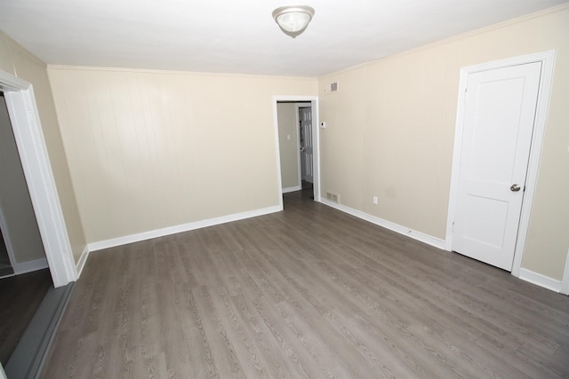 unfurnished bedroom featuring crown molding, baseboards, visible vents, and wood finished floors