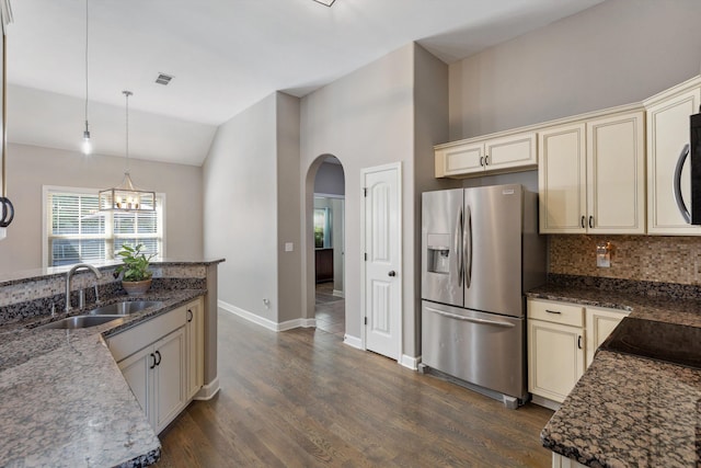 5376 Scarlet Ridge Dr, Arlington, TN 38002 - kitchen with decorative backsplash, arched walkways, a sink, stainless steel fridge, and cream cabinetry