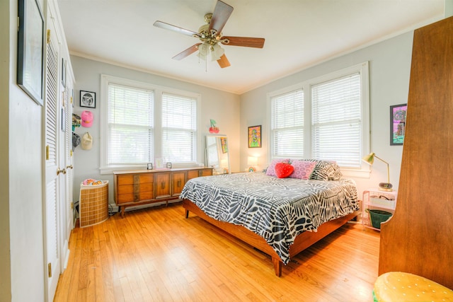 bedroom with ornamental molding, a ceiling fan, and light wood finished floors