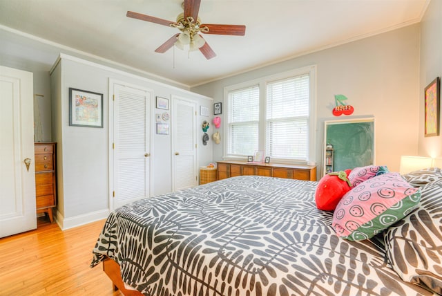 bedroom featuring a ceiling fan, baseboards, ornamental molding, and light wood-style floors