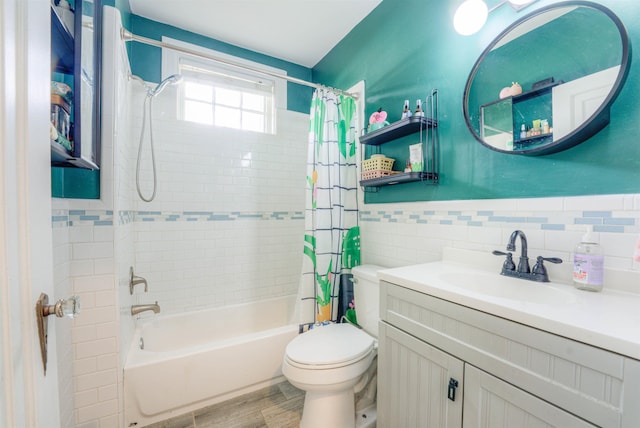 bathroom featuring tile walls, wainscoting, vanity, toilet, and shower / bathtub combination with curtain