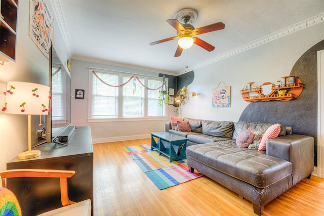 living room featuring baseboards, ceiling fan, crown molding, and wood finished floors