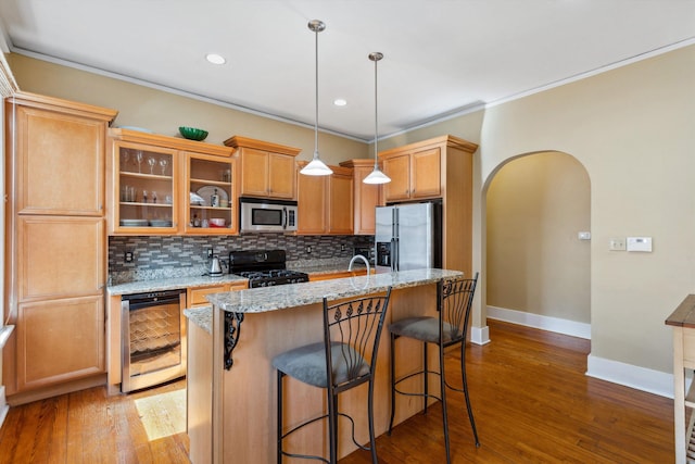 kitchen featuring beverage cooler, stainless steel appliances, baseboards, decorative backsplash, and ornamental molding