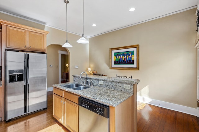 kitchen featuring appliances with stainless steel finishes, arched walkways, a sink, baseboards, and light wood-style flooring