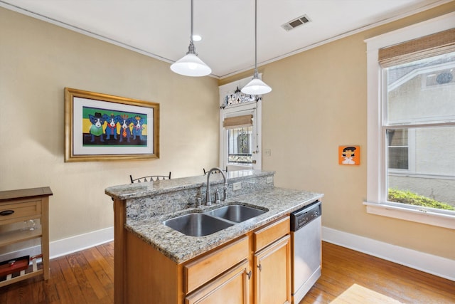 kitchen featuring stainless steel dishwasher, a sink, baseboards, and visible vents