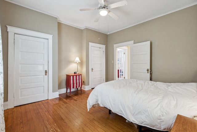 bedroom featuring baseboards, ornamental molding, hardwood / wood-style flooring, and ceiling fan