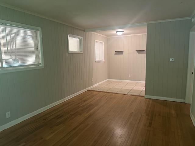 unfurnished room with baseboards, ornamental molding, and hardwood / wood-style floors