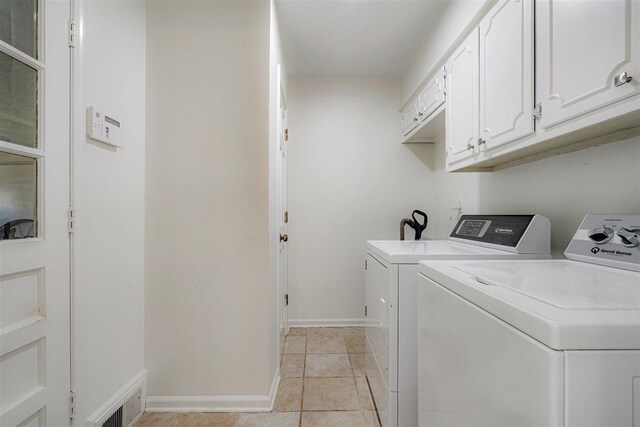 laundry area with visible vents, light tile patterned flooring, baseboards, washer and clothes dryer, and cabinet space