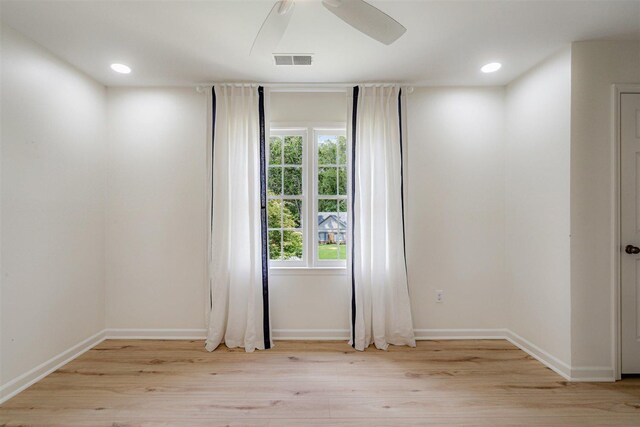 unfurnished room featuring baseboards, a ceiling fan, light wood finished floors, and visible vents