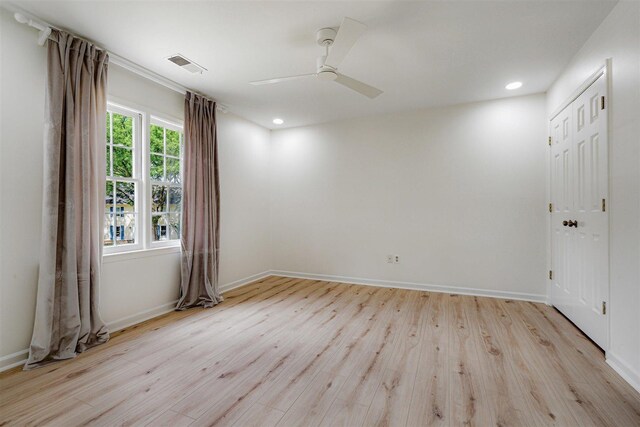 empty room featuring visible vents, light wood finished floors, ceiling fan, and baseboards
