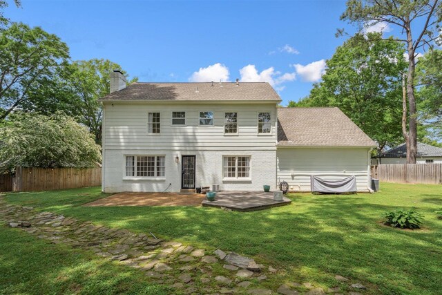 rear view of house with a fenced backyard, a patio area, a yard, and a chimney