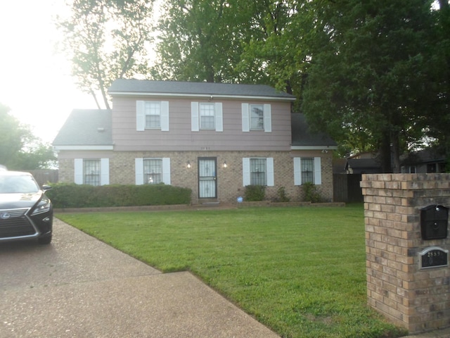 colonial-style house with a front lawn and brick siding