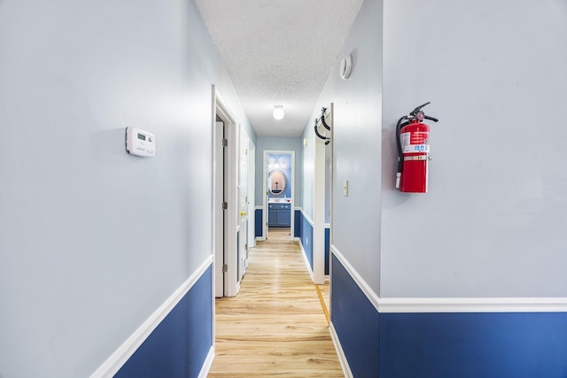 6747 Wild Ln, Bartlett, TN 38135 - corridor with baseboards, light wood-type flooring, and a textured ceiling