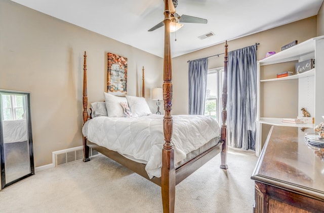 carpeted bedroom with visible vents, baseboards, and ceiling fan