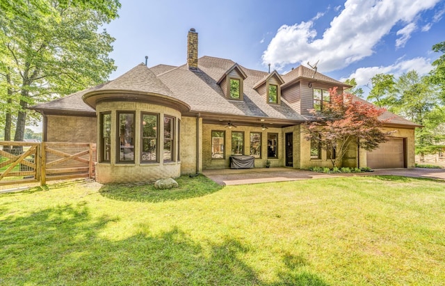 back of property with fence, a chimney, a yard, and aphalt driveway