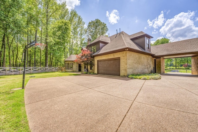 view of property exterior with fence, an attached garage, a shingled roof, brick siding, and a yard