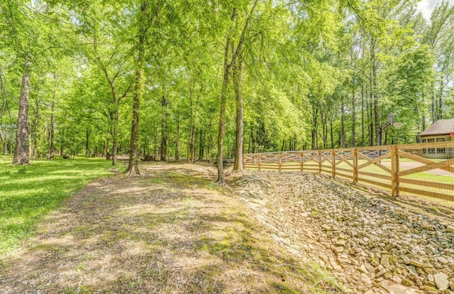 view of yard with fence and a view of trees