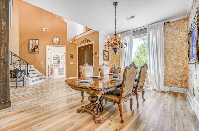 dining space with visible vents, wood finished floors, stairway, baseboards, and an inviting chandelier