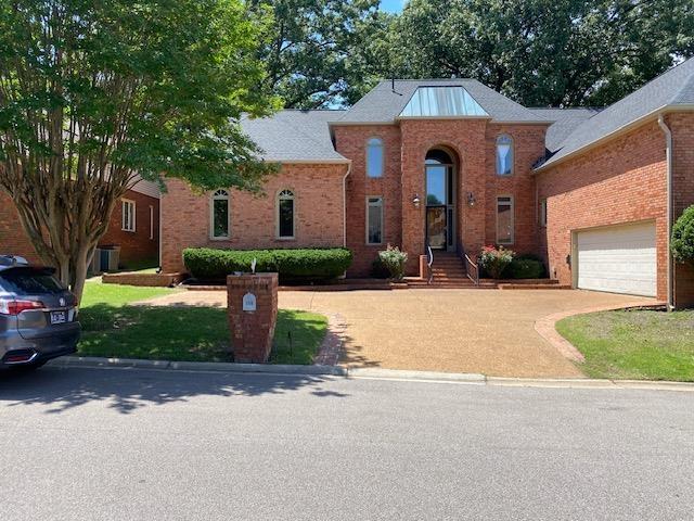 traditional home with a garage, driveway, and brick siding