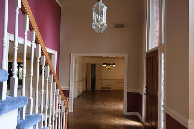 entrance foyer featuring visible vents, a high ceiling, and a notable chandelier